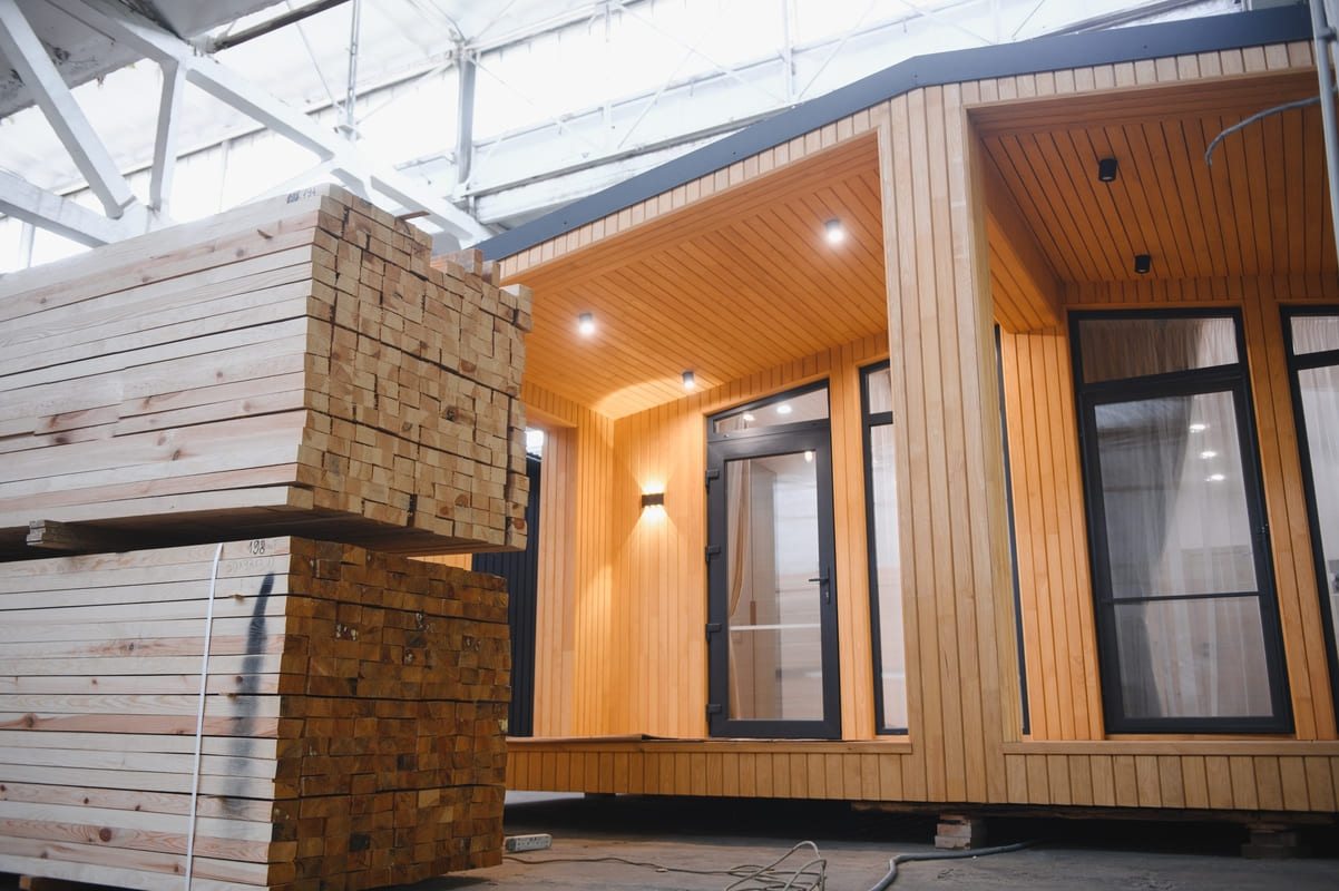 Kodukindlustus ja majaehitus - õue ladustatud ehitusmaterjal majakese ees